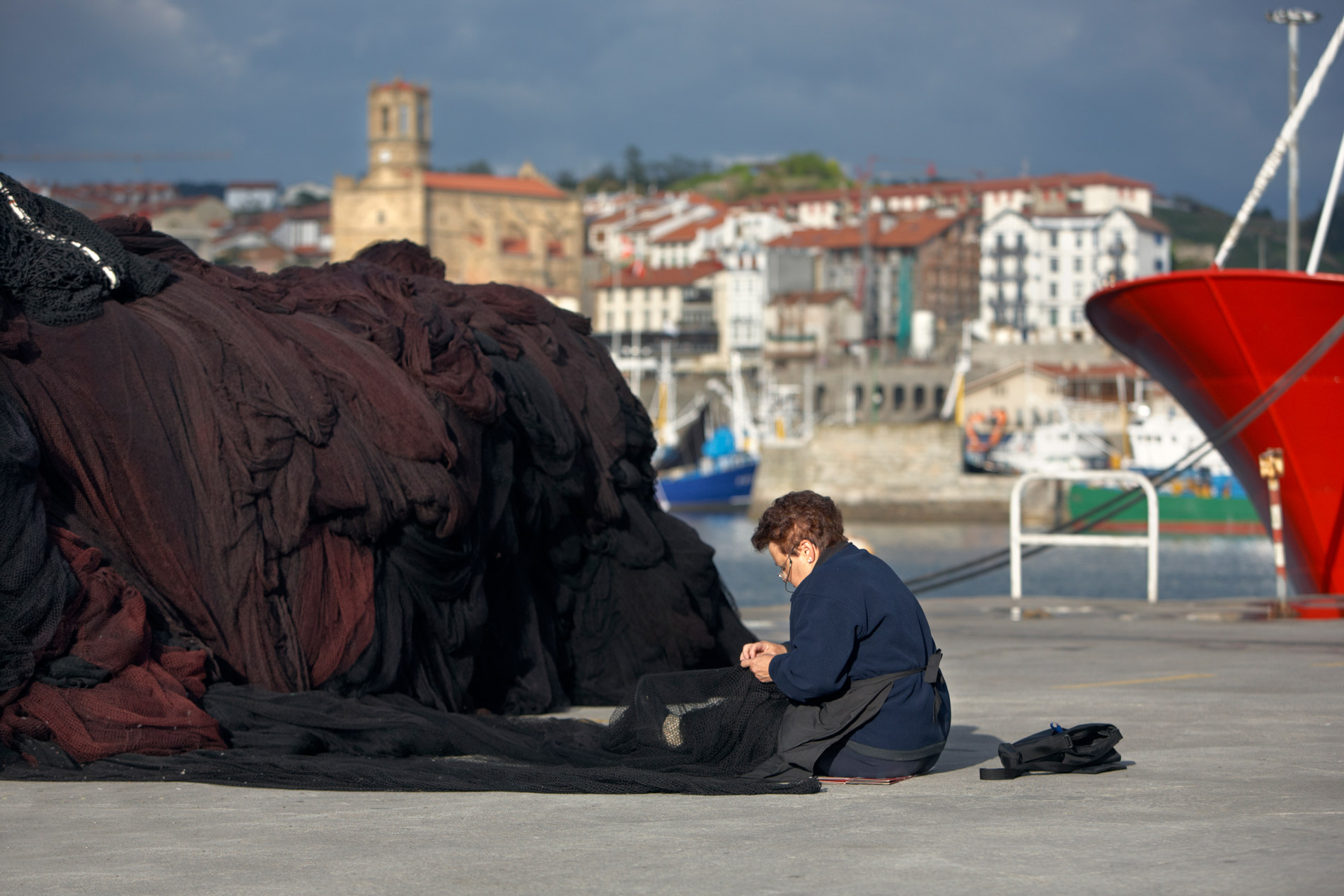 Mujer trabajando con redes de pesca en el puerto de San Sebastián.